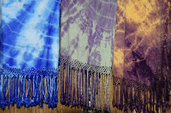 Fes, Northern Morocco, Morocco, Africa, Colourful batik scarves with fringes in blue, purple and yellow hang next to each other, Africa