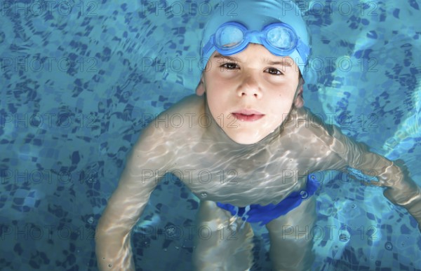 Little boy in swimming pool. Blue swimming pool