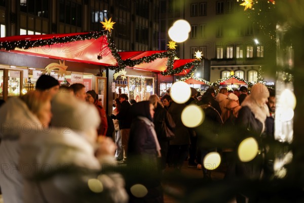 Large crowds of people at a brightly lit Christmas market at night, Cologne, North Rhine-Westphalia, Germany, Europe