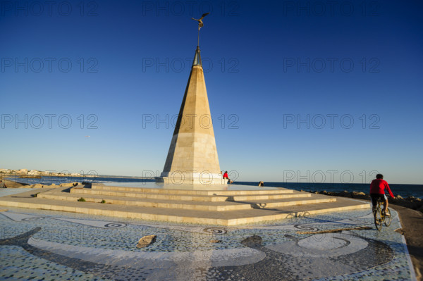 Cyclist next to the monument, Paseo del Molinar, Palma, mallorca, balearic islands, spain
