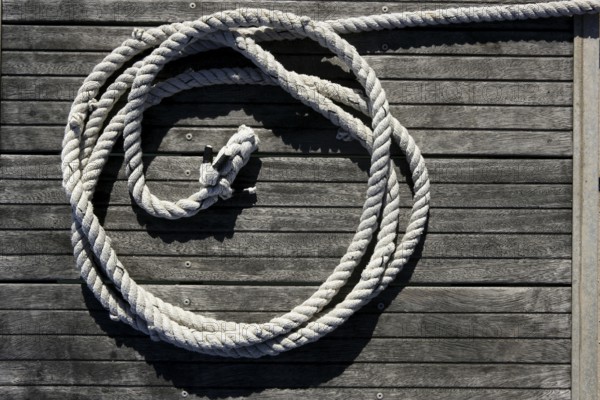 Nautical marine round thread over dried gray teak wood background