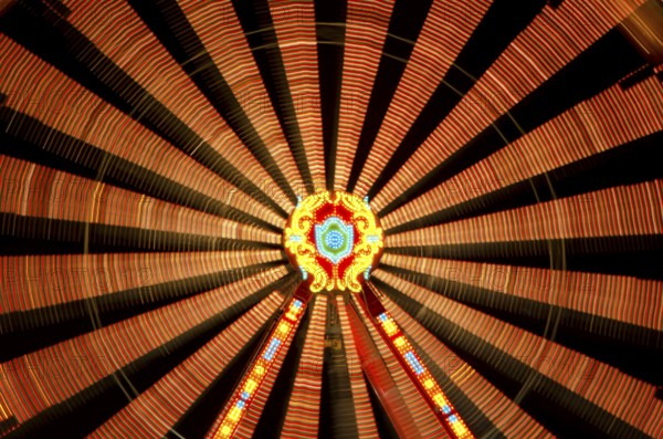 Close Up on an Illuminated Amusement Park Wheel at Night in Long Exposure in SWitzerland