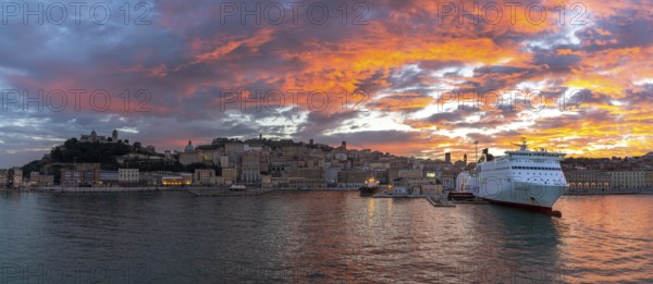 Ancona, Italy, 24 November, 2022: panorama view of the old town and harbor of Ancona with a large cruise ship at the docks at sunrise, Europe