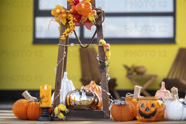 Autumn decor on the porch of the house outside in the yard of pumpkin, lantern, garlands, hats, jack lantern. Halloween party, autumn mood, Harvest festival