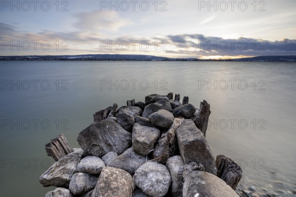 Stone pier jutting into a calm lake, atmospheric clouds in the sky at dusk, calm atmosphere, harbour, Allensbach, Lake Constance, Baden-Württemberg, Germany, Europe
