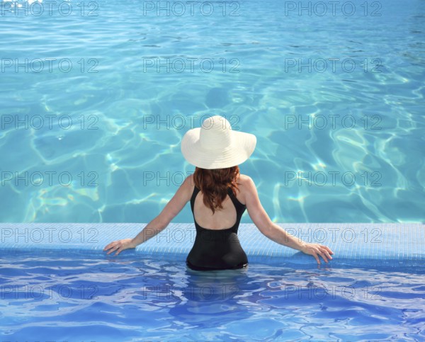 Caribbean tropical sea view from blue pool rear woman beach hat