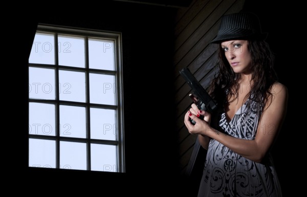 A beautiful police detective woman on the job with a gun