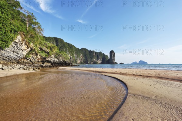 The beach at low tide. A huge puddle of sea water and bright orange sand