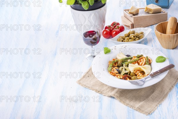 Colourful farfalle with green asparagus olives and parma ham