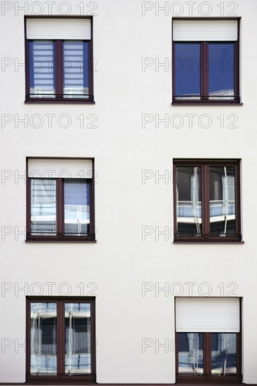The façade of a residential building with windows reflecting the surroundings