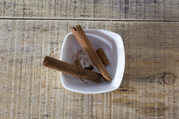 Pair of cinnamon sticks in a white bowl