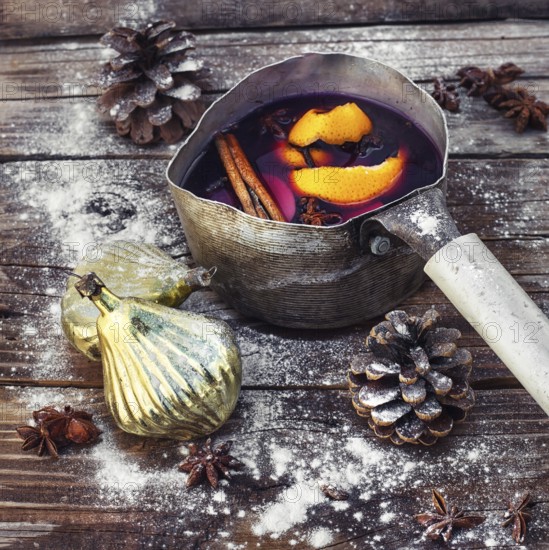 Old pot with long handle welded with mulled wine on the Christmas decor