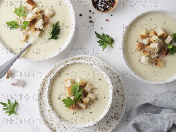 Cauliflower potato soup puree on white marble tabletop, Creamy cauliflower soup with toasted bread croutons. Vegetarian healthy food concept. Ideas and recipes for winter meal. Top view or flat lay
