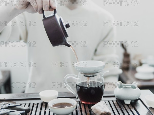 Chinese tea ceremony. Master pouring puer tea in glass teapot. Pu erh tea ceremony