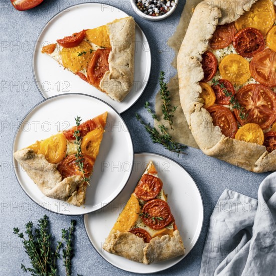 Savory fresh homemade tomato tart or galette.Ideas and recipes for healthy lunch, appetiezer- whole wheat or rye-wheat pie with tomatoes, parmesan cheese, mozzarella.Harvest tomatoes.Top view or flat lay