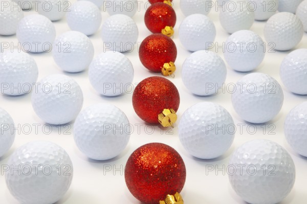 Pattern with white golf balls and red Christmas decoration on the table