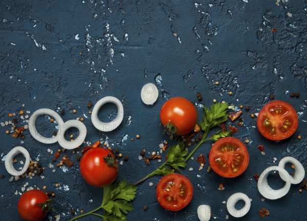 Vegetables background. Fresh vegetables (garlic, tomatoes, onions) on a dark embossed surface. View from above. Copy space