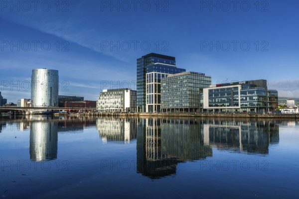 Belfast, United Kingdom, 21 August, 2022: skyline of downtown Belfast with skyscrapers and reflections in the calm River Lagan at dawn, Europe