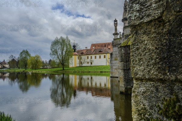 River landscape with stone bridge and historic buildings, reflections on water, cloudy sky, Tirschenreuth, Upper Palatinate, Bavaria, Germany, Europe