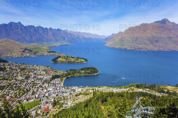 Huge azure lake among the mountains. Bird's eye view. Travel to New Zealand, South Island. The city - resort Queenstown, shores of Lake Wakatipu. The concept of active, ecological and photo tourism