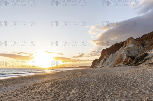 The golden sandy beach of Praia da Falésia with its characteristic orange-coloured cliffs, landscape shot in the evening at sunset on the cliffs in the Algarve, Portugal, Europe