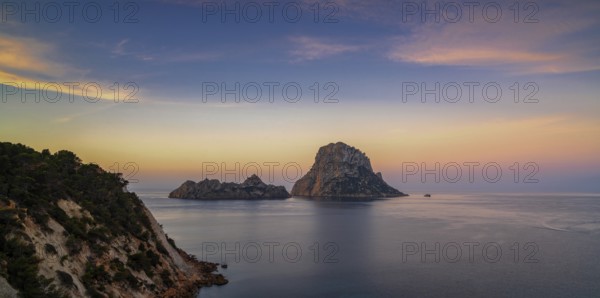 A panorama landscape view of the landmark Es Vedra island and rocks off the coast of Ibiza at sunrise