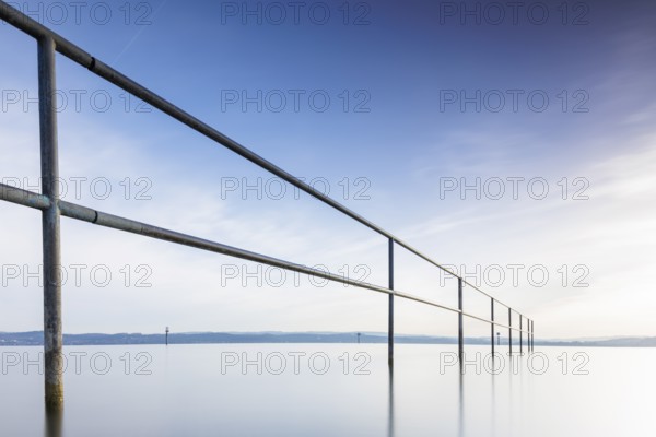 A railing in front of a calm, blue sky and lake, lido, Litzelstetten, Lake Constance, Baden-Württemberg, Germany, Europe
