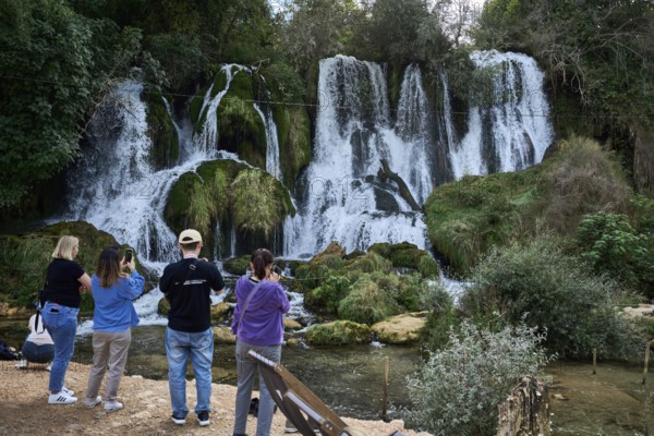 Kravica waterfalls, tourists photographing the waterfall, Trebižat river, near the village of Studenci, Bosnia and Herzegovina, Europe