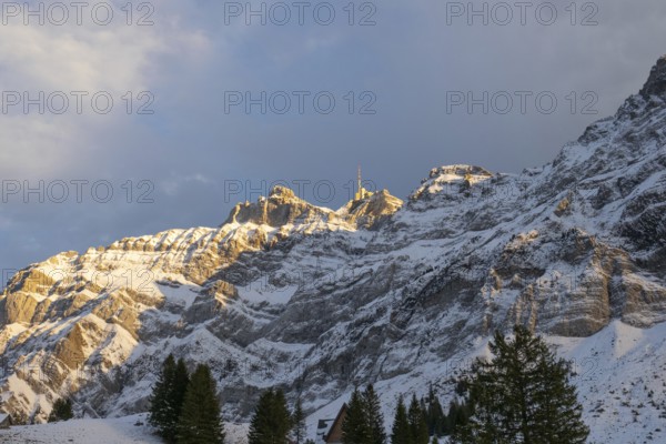 View from Schwägalp into the northern rock wall of Säntis, the highest mountain in the Alpstein massif, Switzerland. First snow in the autumn, the mountain appears in late afternoon sunlight