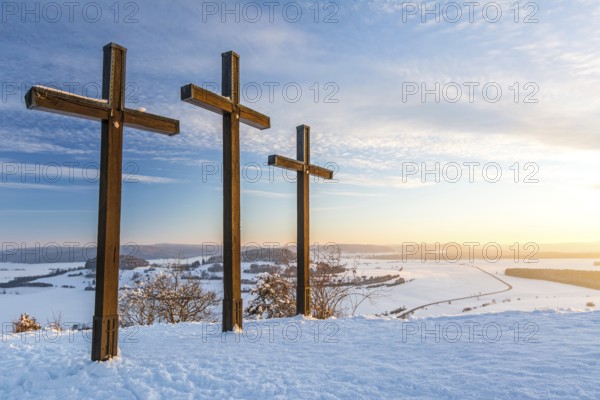 Summit crosses on a mountain peak in a beautiful winter landscape in the Swabian Alps at sunset