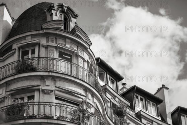 Details of a residential building with curved walls, balconies and ornate iron railings in Paris, France, Europe