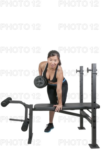 A beautiful young Asian woman using weights during a workout