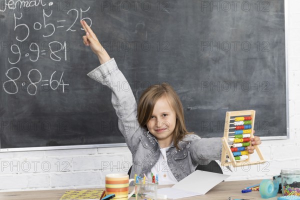 The girl raised her hand in class. The student knows the solution of the task given by the teacher. Eager to answer