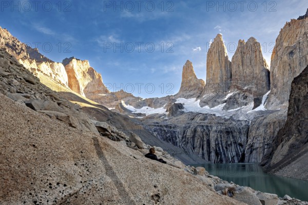 High cliffs next to a turquoise-coloured lake in a remote landscape, The rock towers of Torres del Paine in Patagonia Chile