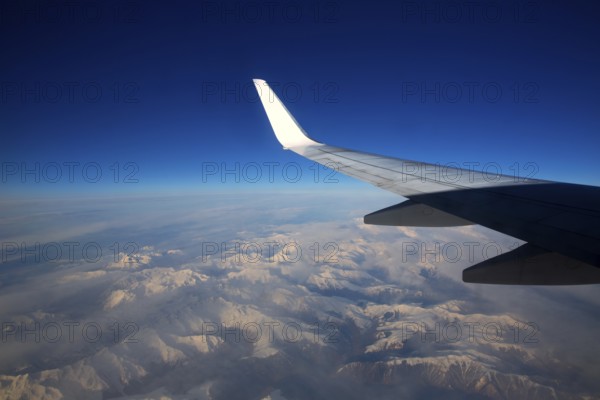 Aircraft flying over snowed mountains of Pyrenees between France and Spain