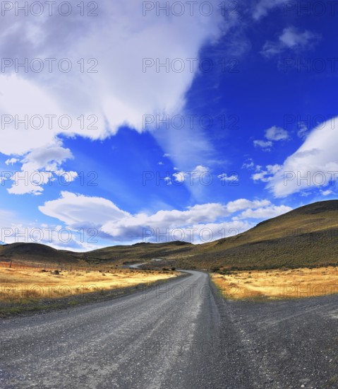 Picture taken with a fisheye lens. The dirt road in the Chile National Park Torres del Paine. Magic clouds incredible shapes formed by glaciers shining in the sun. Patagonia