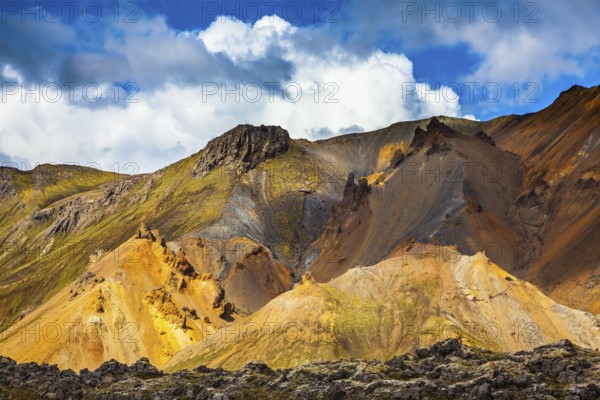 Multicolored rhyolite mountains highlights the July sun. Travel to Iceland in the summer. National Park Landmannalaugar