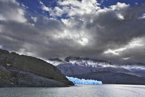 Journey to the End of the World. Chilean Patagonia in the clouds and sunshine. Blue Ice Glacier Gray is reflected in the lake