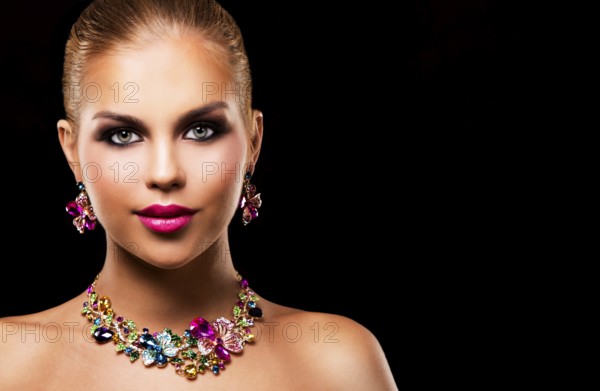Beautiful woman with dark makeup and pink lipstick posing on black background wearing flower spring and summer jewellry necklace, Toronto, Canada, North America