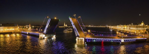 Aerial panorama of the drawn Palace bridge, Winter Palace, Peter and Paul Fortress and Rostral Columns in St. Petersburg at night, Russia, Europe