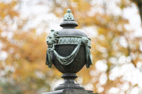 Ancient burial urn in a historic cemetery in autumn
