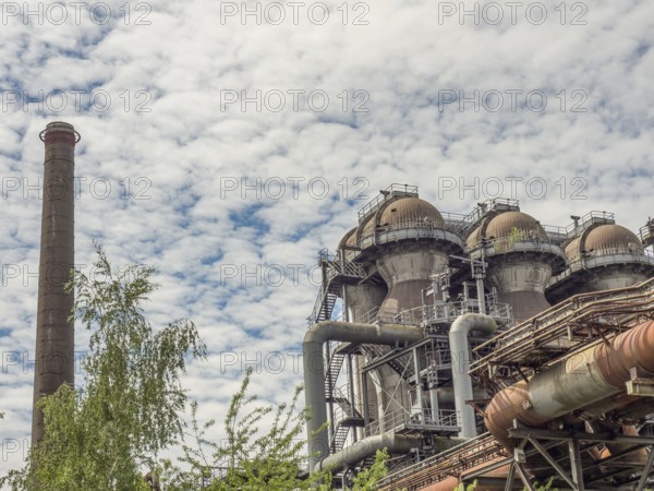 Industrial plant with chimney and metallic constructions under a cloudy sky, Duisburg, Ruhr area, Germany, Europe