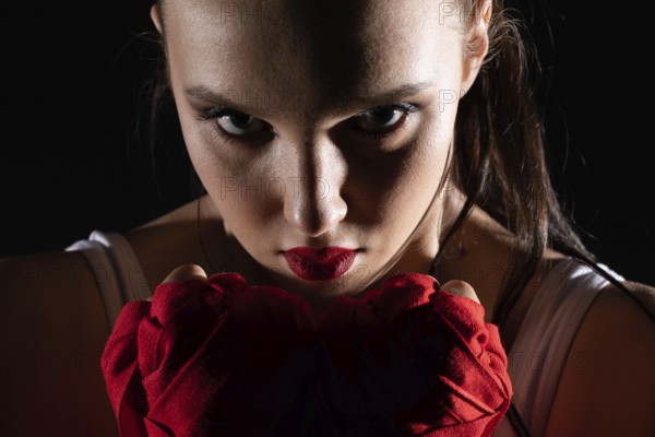The head is hidden behind the strong guard of a professional sportswoman. A strong and athletic woman in the ring of sports which is MMA