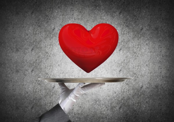 Cropped image of waitress's hand in white glove presenting big red heart on metal tray with dark wall on background