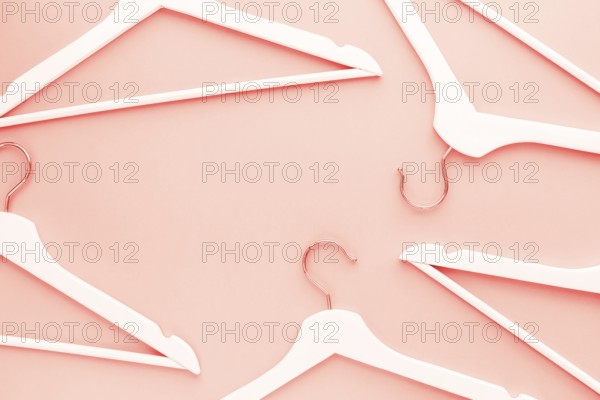 Creative top view flat lay wooden hangers toned living coral color of the year 2019 background copy space minimalism style. Template fashion blog social media sale store promo design shopping concept