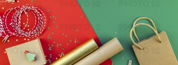 New Year or Christmas presents preparation DIY flat lay top view Xmas holiday celebration handmade gift boxes on red green paper background. Long wide banner greeting card or your text design 2019