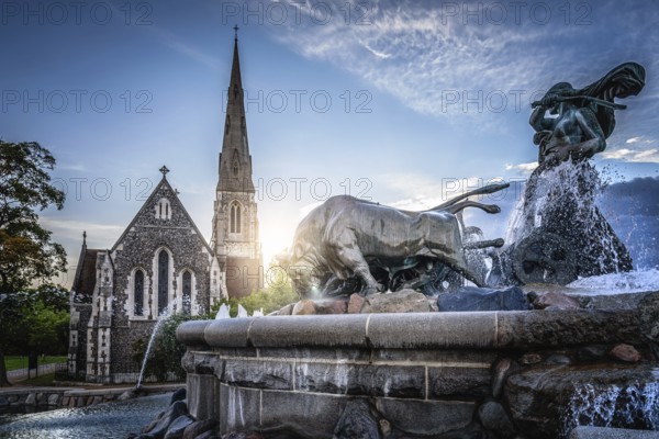 Copenhagen, Denmark, August 10, 2016. The Gefion Fountain is a large fountain in Copenhagen, view with church and sunlight on background. It is located in Langelinie Park is the largest monument in Copenhagen and used as a wishing well, Europe