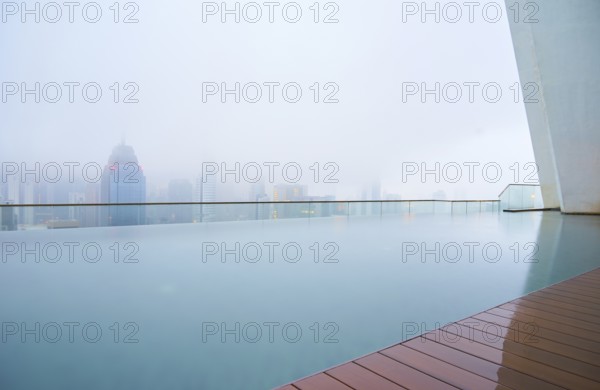 Swimming pool on roof top with beautiful city skyline view, early morning with mist, kuala lumpur malaysia