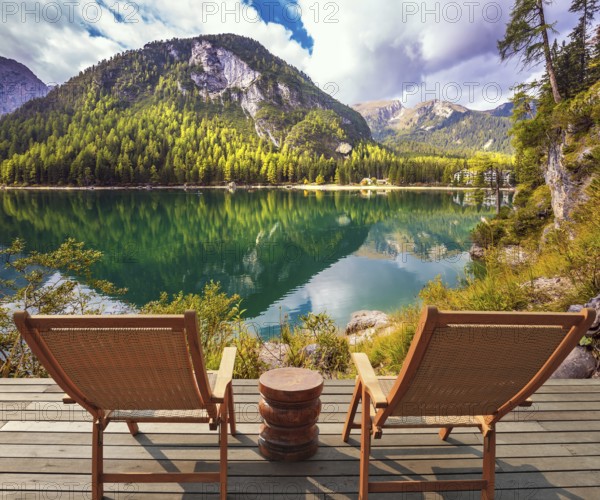 Pair of sun loungers on the lake. Magnificent lake in South Tyrol, Italy. The concept of walking and eco-tourism. Water reflects the surrounding mountains and forest