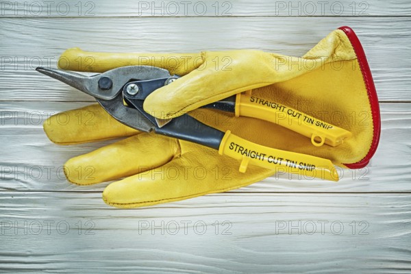 Protective gloves tin snip on wooden board